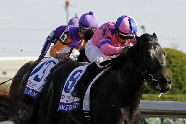 Jockey Corey Nakatani rides Dance With Fate to victory over Medal Count in the Blue Grass Stakes horse race at Keeneland in Lexington, Ky., Saturday, April 12, 2014. (AP Photo/Garry Jones)