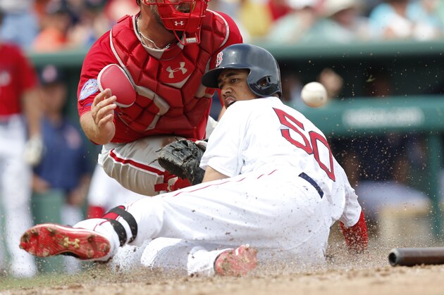 Boston Red Sox's Mookie Betts (50) slides into home against Philadelphia Phillies' catcher Cameron Rupp after hitting a solo home run in the bottom of the third inning during an exhibition spring training baseball game, Sunday, March 22, 2015, in Fort Myers, Fla. (AP Photo/Brynn Anderson)