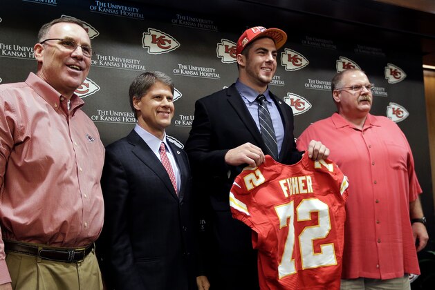 Kansas City Chiefs No. 1 draft pick Eric Fisher, an offensive lineman from Central Michigan, poses with  general manager John Dorsey, left, coach Andy Reid, right, and owner Clark Hunt during an NFL football news conference Friday, April 26, 2013, in Kansas City, Mo. Fisher was the No. 1 overall pick in the NFL draft on Thursday. (AP Photo/Charlie Riedel)
