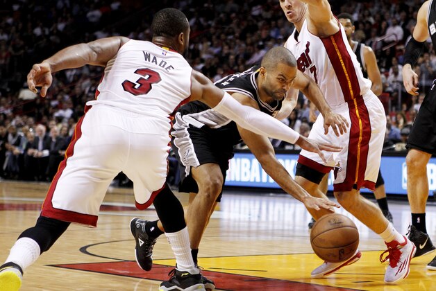 Tony Parker, de los Spurs de San Antonio pasa entre Dwyane Wade y Goran Dragic, del Heat de Miami, durante el partido del martes 31 de marzo de 2015 (AP Foto/Joe Skipper)