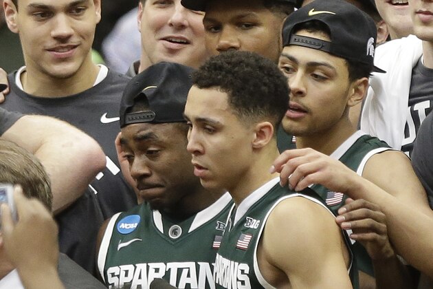Michigan State's Lourawls Nairn Jr., left, and Travis Trice (20) stand during the awards ceremony after the East Regional final against Louisville in the NCAA men's college basketball tournament Sunday, March 29, 2015, in Syracuse, N.Y. Michigan State won 76-70. (AP Photo/Heather Ainsworth)