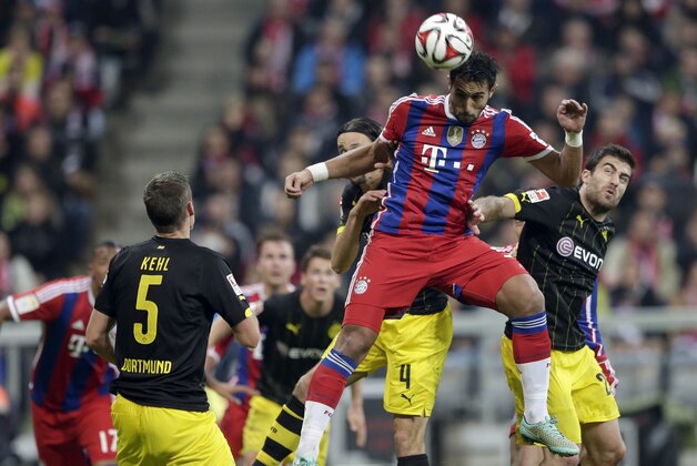 Bayern’s Mehdi Benatia, top, and Dortmund's Sokratis challenge for the ball during the German first division Bundesliga soccer match between FC Bayern and Borussia Dortmund in the Allianz Arena in Munich, Germany, on Saturday, Nov. 1, 2014. (AP Photo/Matthias Schrader)