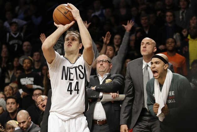 Brooklyn Nets' Bojan Bogdanovic (44), of Croatia, makes a 3-point basket as Milwaukee Bucks' Jerryd Bayless, right, yells at him from the bench during the overtime period of an NBA basketball game Friday, March 20, 2015, in New York. The Nets won the game 129-127. (AP Photo/Frank Franklin II)