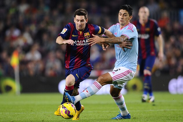 FC Barcelona's Lionel Messi, left, duels for the ball against Celta de Vigo's Pablo Hernandez during a Spanish La Liga soccer match at the Camp Nou stadium in Barcelona, Spain, Saturday, Nov. 1, 2014. (AP Photo/Manu Fernandez)