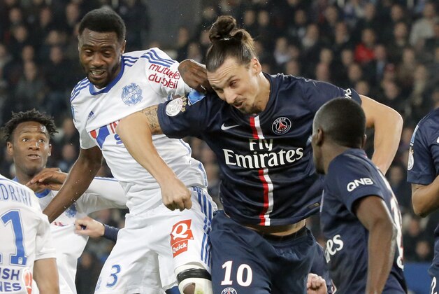 Paris Saint Germain's Zlatan Ibrahimovic challenge for the ball with Marseille's Nicolas N'Koulou during their French League One soccer match match between Paris Saint Germain and Marseille at Parc des Princes stadium in Paris, France, Sunday, Nov. 9, 2014. (AP Photo/Francois Mori)