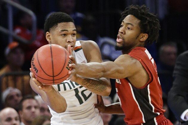 Stanford's Chasson Randle, right, reaches for the ball held by Miami's James Palmer (12) during the second half of the championship game at the NIT college basketball tournament Thursday, April 2, 2015, in New York. Stanford won 66-64 in overtime. (AP Photo/Frank Franklin II)