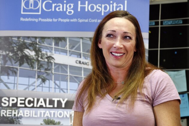 Olympic swimmer Amy Van Dyken-Rouen talks with members of the media as she leaves Craig Hospital in Englewood, Colo., Thursday, Aug. 14, 2014. Van Dyken-Rouen was left paralyzed just below the waist in an all-terrain vehicle crash on June 6 in Arizona. (AP Photo/Brennan Linsley)