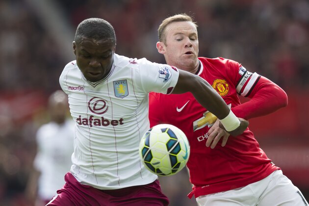 Manchester United's Wayne Rooney, right, fights for the ball against Aston Villa's Jores Okore during the English Premier League soccer match between Manchester United and Aston Villa  at Old Trafford Stadium, Manchester, England, Saturday, April 4, 2015. (AP Photo/Jon Super)