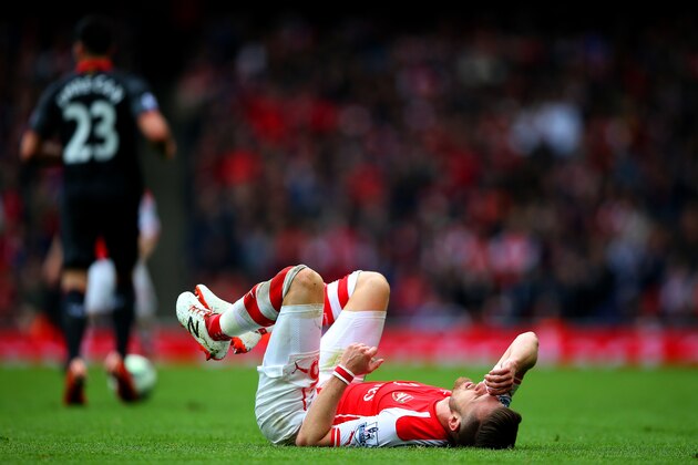 LONDON, ENGLAND - APRIL 04:  Aaron Ramsey of Arsenal goes to ground during the Barclays Premier League match between Arsenal and Liverpool at Emirates Stadium on April 4, 2015 in London, England.  (Photo by Paul Gilham/Getty Images)