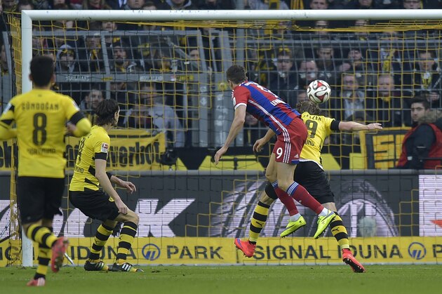 Bayern's Robert Lewandowski, center,  scores the opening goal during the German Bundesliga soccer match between Borussia Dortmund and Bayern Munich in Dortmund, Germany, Saturday, April 4, 2015.  (AP Photo/Martin Meissner)