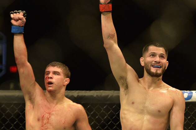 Apr 4, 2015; Fairfax, VA, USA; Jorge Masvidal (red gloves) and Al Iaquinta (blue gloves) gesture to the fans after their fight during UFC Fight Night at Patriot Center. Mandatory Credit: Tommy Gilligan-USA TODAY Sports