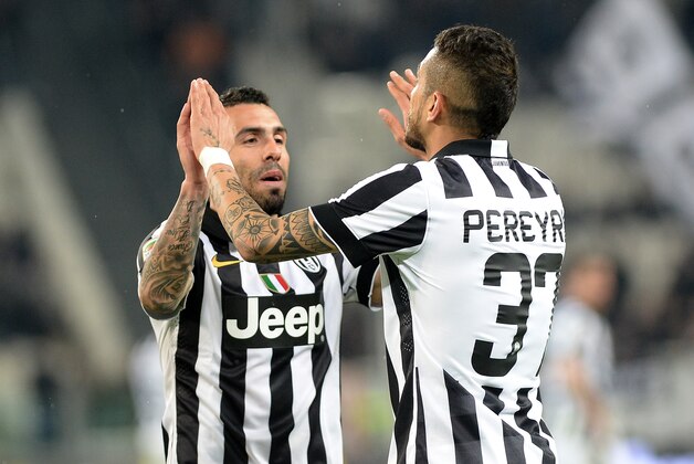 Juventus' Roberto Pereyra, right, celebrates with his teammates Carlos Tevez after scoring during a Serie A soccer match between Juventus and Empoli at the Juventus stadium, in Turin, Italy, Saturday, April 4, 2015. (AP Photo/ Massimo Pinca)