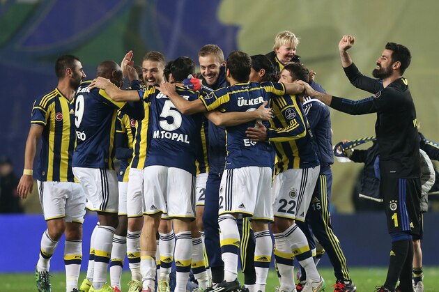 Fenerbahce's Dirk Kuyt holds up on his shoulder one of his three children as he celebrates with team mates after their Turkish League soccer derby match with Galatasaray at the Sukru Saracoglu Stadium in Istanbul, Turkey, Sunday, March 8, 2015.(AP Photo/Emrah Gurel)