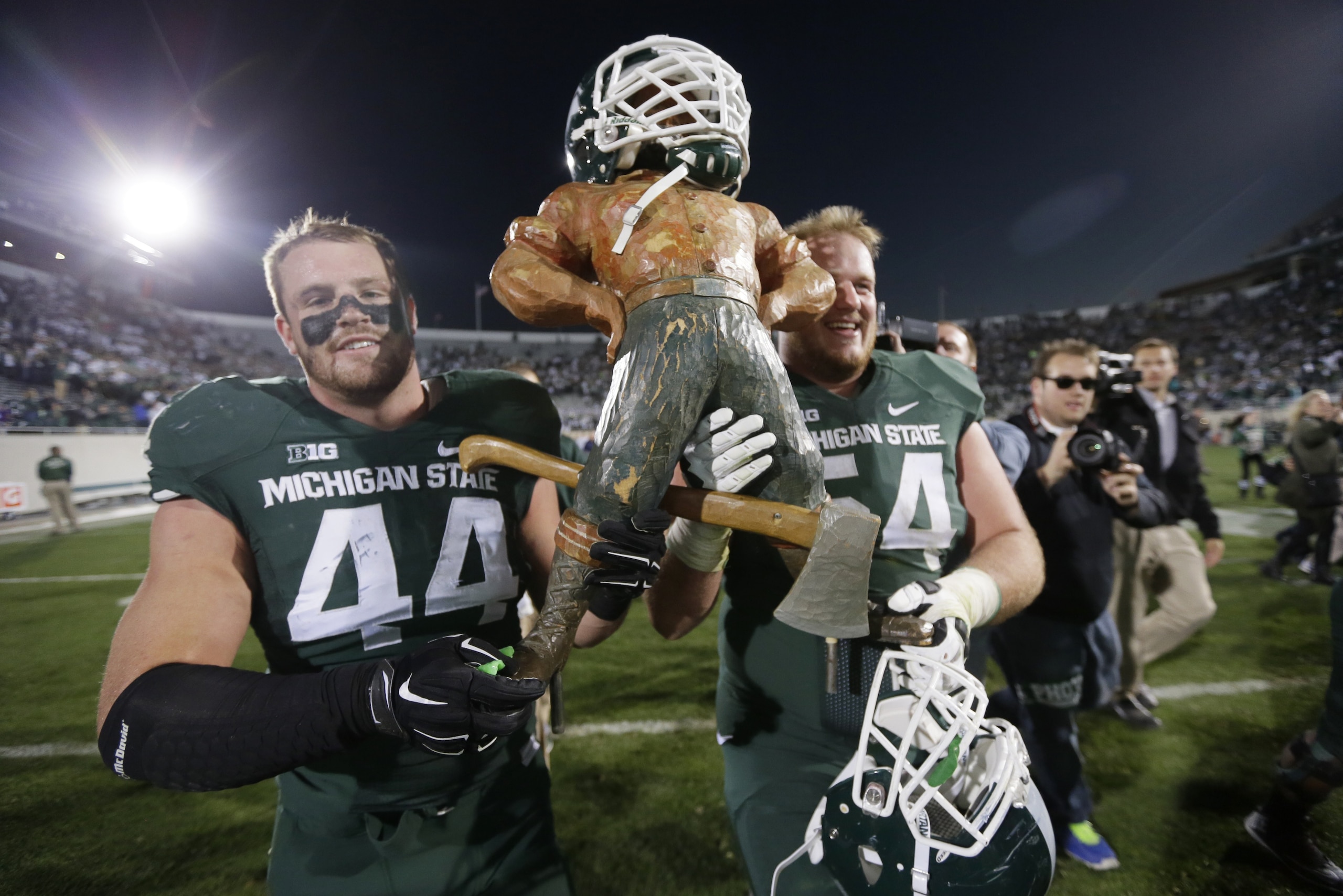 Michigan State defensive end Marcus Rush (44) and guard Connor Kruse (54) carry off the Paul Bunyan trophy after their 35-11 win over in an NCAA college football game in East Lansing, Mich., Saturday, Oct. 25, 2014. (AP Photo/Carlos Osorio)