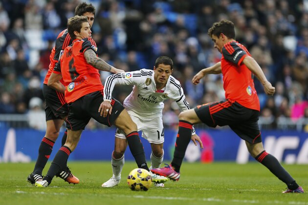 Real Madrid's Chicharito, center, tries to get through the Real Sociedad defense during a Spanish La Liga soccer match between Real Madrid and Real Sociedad at the Santiago Bernabeu stadium in Madrid, Spain, Saturday Jan. 31, 2015. (AP Photo/Paul White)