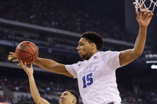 Duke's Jahlil Okafor (15) tries to block a shot by Michigan State's Travis Trice, left, during the first half of the NCAA Final Four tournament college basketball semifinal game Saturday, April 4, 2015, in Indianapolis. (AP Photo/David J. Phillip)