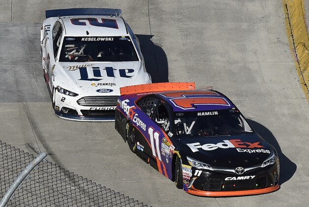 Denny Hamlin (11) heads to the finish line as Brad Keslowski (2) closes in during the NASCAR Sprint Cup auto race at Martinsville Speedway in Martinsville, Va., Sunday, March 29, 2015. Hamlin won the race. (AP Photo/Don Petersen)