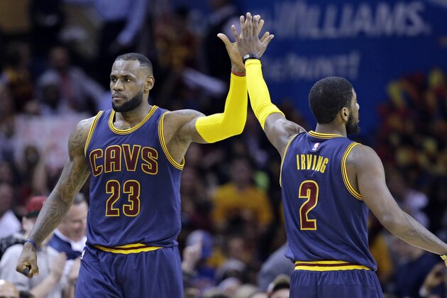 Cleveland Cavaliers' LeBron James (23) and Kyrie Irving (2) celebrate during an NBA basketball game against the Miami Heat Thursday, April 2, 2015, in Cleveland. (AP Photo/Tony Dejak)