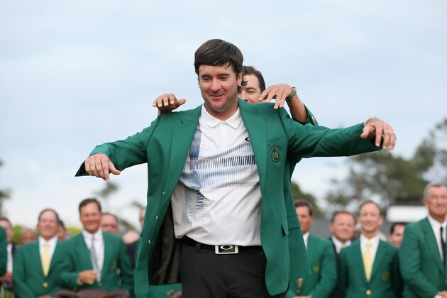 AUGUSTA, GA - APRIL 13:  Adam Scott of Australia presents Bubba Watson of the United States with the green jacket after Watson won the 2014 Masters Tournament by a three-stroke margin at Augusta National Golf Club on April 13, 2014 in Augusta, Georgia.  (Photo by Ezra Shaw/Getty Images for Golfweek)