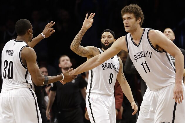 Brooklyn Nets' Deron Williams (8) celebrates with Brook Lopez (11) and Thaddeus Young (30) after Williams made a three-point basket during the second half of an NBA basketball game against the Toronto Raptors Friday, April 3, 2015, in New York. The Nets won the game 114-109. (AP Photo/Frank Franklin II)
