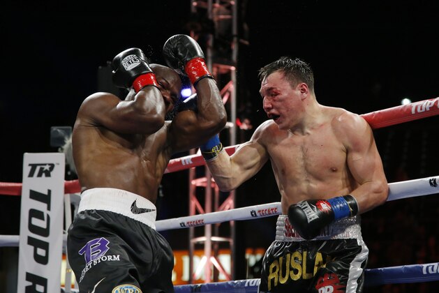 Timothy Bradley, left, takes a punch from Ruslan Provodnikov, of Russia, in the ninth round of a WBO welterweight title boxing match in Carson, Calif., Saturday, March 16, 2013. (AP Photo/Jae C. Hong)