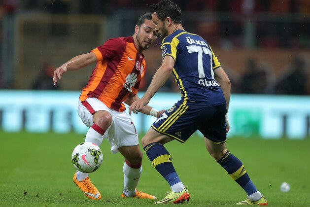 Galatasaray's Tarik Camdal, left, and Gokhan Gonul of Fenerbahce fight for the ball during their Turkish League soccer derby match at the TT Arena stadium in Istanbul, Turkey, Saturday, Oct. 18, 2014.(AP Photo)