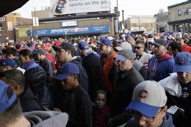 Baseball fans arrive at Wrigley Field before a Major League Baseball season-opening game between the Chicago Cubs and the St. Louis Cardinals in Chicago, Sunday, April 5, 2015. (AP Photo/Nam Y. Huh)