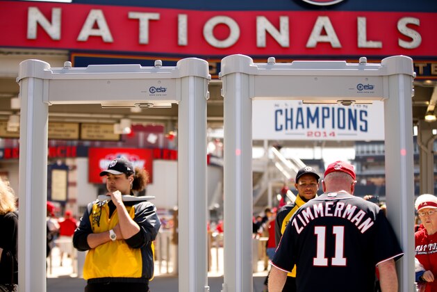 A fan passes through a metal detector at the stadium's center field gate before a baseball game between the Washington Nationals and the New York Mets on opening day at Nationals Park, Monday, April 6, 2015, in Washington. (AP Photo/Andrew Harnik)