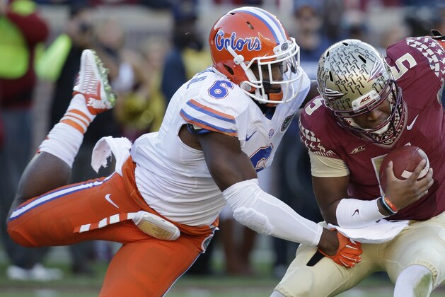 Florida State quarterback Jameis Winston (5) manages to escape a sack as he is hit by Florida defensive lineman Dante Fowler, Jr. (6) during the first half of an NCAA college football game in Tallahassee, Fla., Saturday, Nov. 29, 2014. (AP Photo/John Raoux)