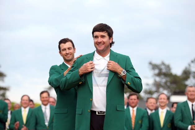 AUGUSTA, GA - APRIL 13:  Adam Scott of Australia presents Bubba Watson of the United States with the green jacket after Watson won the 2014 Masters Tournament by a three-stroke margin at Augusta National Golf Club on April 13, 2014 in Augusta, Georgia.  (Photo by Ezra Shaw/Getty Images for Golfweek)