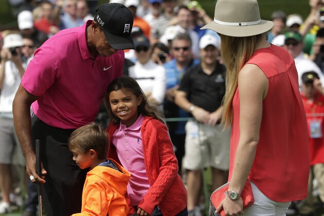 Lindsey Vonn watches as Tiger Woods hugs his children Charlie, left and Sam during a practice round for the Masters golf tournament Tuesday, April 7, 2015, in Augusta, Ga. (AP Photo/Chris Carlson)
