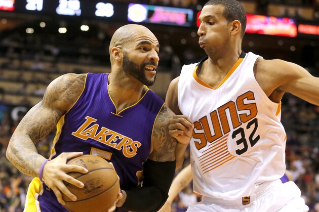 Los Angeles Lakers forward Carlos Boozer (5), left, drives on Phoenix Suns forward Brandan Wright (32) in the first quarter during an NBA basketball game, Monday, Jan. 19, 2015, in Phoenix. (AP Photo/Rick Scuteri)