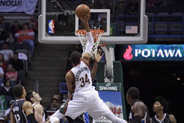 Milwaukee Bucks forward Giannis Antetokounmpo, center, goes up for a basket against the Orlando Magic during the first half of an NBA basketball game Saturday, April 4, 2015, in Milwaukee. (AP Photo/Darren Hauck)