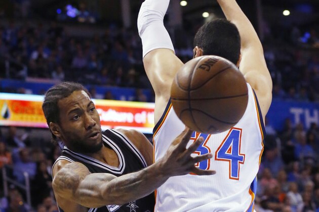 San Antonio Spurs forward Kawhi Leonard, left, passes around Oklahoma City Thunder center Enes Kanter (34) during the third quarter of an NBA basketball game in Oklahoma City, Tuesday, April 7, 2015. San Antonio won 113-88. (AP Photo/Sue Ogrocki)