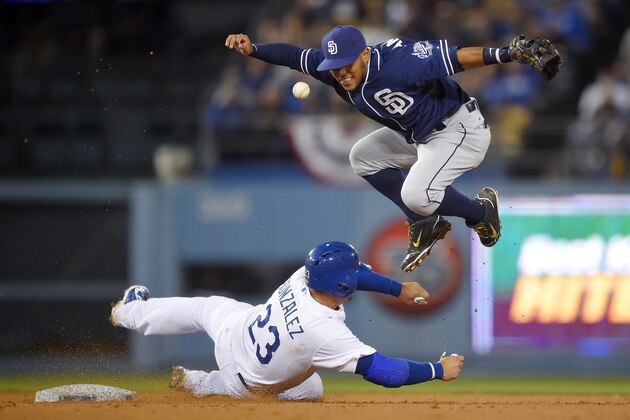 San Diego Padres shortstop Alexi Amarista, right, loses control of the ball and a chance at a double play after forcing out Los Angeles Dodgers' Adrian Gonzalez at second on a ball hit by Howie Kendrick during the fourth inning of a baseball game, Tuesday, April 7, 2015, in Los Angeles. (AP Photo/Mark J. Terrill)