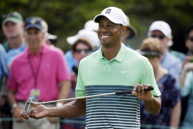 Tiger Woods smiles as waits to putt during a practice round for the Masters golf tournament Wednesday, April 8, 2015, in Augusta, Ga. (AP Photo/Darron Cummings)