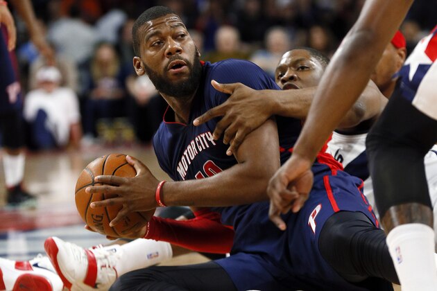 Detroit Pistons forward Greg Monroe (10) looks to pass from the floor as Washington Wizards center Kevin Seraphin (13) defends in the first half of an NBA basketball game in Auburn Hills, Mich., Sunday, Feb. 22, 2015. (AP Photo/Paul Sancya)