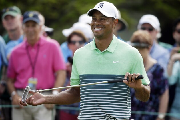 Tiger Woods smiles as waits to putt during a practice round for the Masters golf tournament Wednesday, April 8, 2015, in Augusta, Ga. (AP Photo/Darron Cummings)