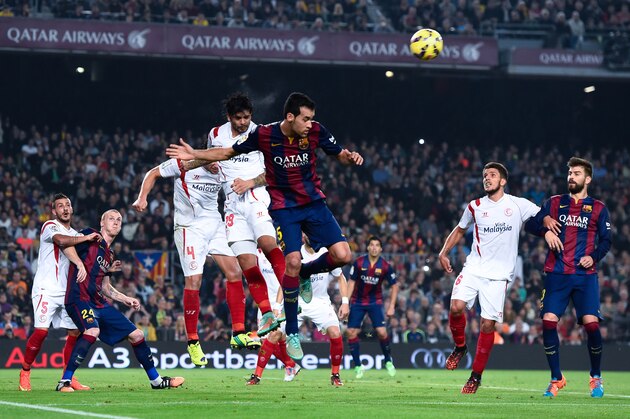 BARCELONA, SPAIN - NOVEMBER 22:  Ever Banega of Sevilla FC clear the ball under pressure from Sergio Busquets of FC Barcelona during the La Liga mach between FC Barcelona and Sevilla FC at Camp Nou on November 22, 2014 in Barcelona, Spain.  (Photo by David Ramos/Getty Images)