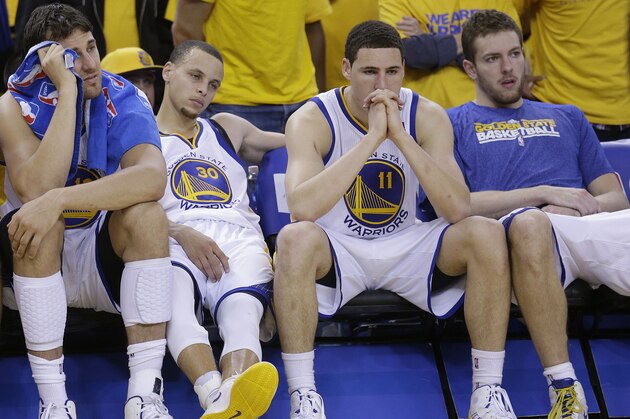 Golden State Warriors power forward Andris Biedrins, from left, center Andrew Bogut, shooting guard Stephen Curry (30), shooting guard Klay Thompson (11), and power forward David Lee sit on the bench during the fourth quarter of Game 6 of a Western Conference semifinal NBA basketball playoff series against the San Antonio Spurs in Oakland, Calif., Thursday, May 16, 2013. The Spurs won 94-82. (AP Photo/Jeff Chiu)