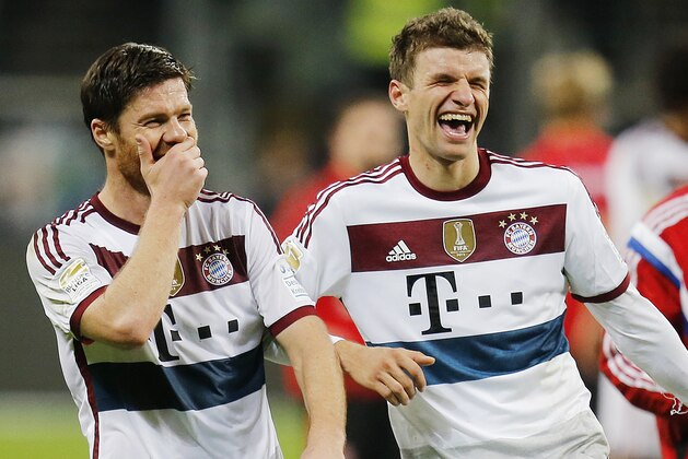 Bayern's Thomas Mueller, right, and Bayern's Xabi Alonso joke after the German first division Bundesliga soccer match between Eintracht Frankfurt and Bayern Munich in the Commerzbank Arena in Frankfurt, Germany, Saturday, Nov. 8, 2014. (AP Photo/Michael Probst)