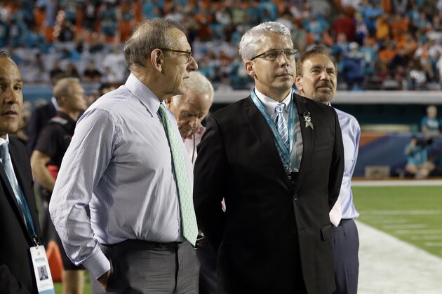Miami Dolphins owner Stephen Ross, left, stands with general manager Dennis Hickey, right, on the field in the second half of an NFL football game against the Buffalo Bills, Thursday, Nov. 13, 2014, in Miami Gardens, Fla. The Dolphins defeated the Bills 22-9. (AP Photo/Lynne Sladky)