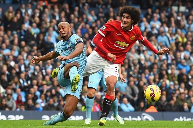 MANCHESTER, ENGLAND - NOVEMBER 02:  Vincent Kompany of Manchester City and Marouane Fellaini of Manchester United battle for the ball during the Barclays Premier League match between Manchester City and Manchester United at Etihad Stadium on November 2, 2014 in Manchester, England.  (Photo by Laurence Griffiths/Getty Images)