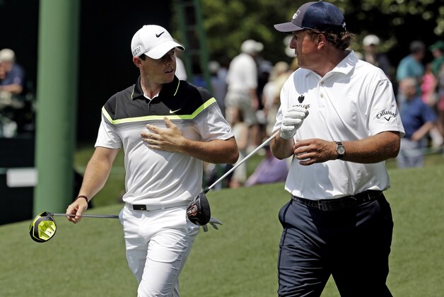 Rory McIlroy, of Northern Ireland, walks down the ninth fairway with Phil Mickelson, right, during the first round of the Masters golf tournament Thursday, April 9, 2015, in Augusta, Ga. (AP Photo/Charlie Riedel)