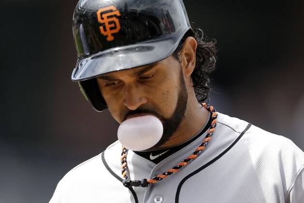 The San Francisco Giants' Angel Pagan blows a bubble with bubble gum after arriving safely to first during the third inning against the San Diego Padres Monday, Sept. 2, 2013, in San Diego. (AP Photo/Gregory Bull)