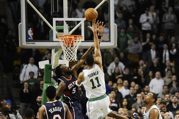 Evan Turner (11), de los Celtics de Boston, dispara la canasta del triunfo frente a DeMarre Carroll (5), de los Hawks de Atlanta, a dos décimas de segundo del final del último periodo el miércoles 11 de febrero de 2015, en Boston. Los Celtics ganaron 89-88. (Foto AP/Jessica Hill)