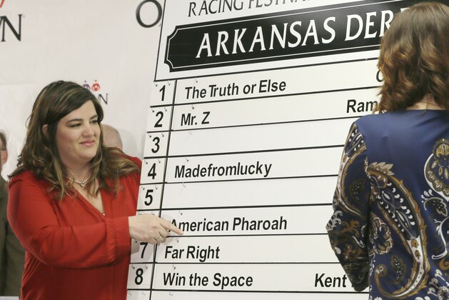 Sara Jeffers, left, and Hilari Burns place the name of thoroughbred American Pharoah in the sixth position in the post position draw for Saturday's running of the $1 million Arkansas Derby horse race at Oaklawn Park in Hot Springs, Ark., Wednesday, April 8, 2015. (AP Photo/Danny Johnston)