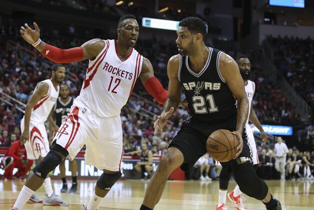 Apr 10, 2015; Houston, TX, USA; San Antonio Spurs forward Tim Duncan (21) dribbles the ball as Houston Rockets center Dwight Howard (12) defends during the first quarter at Toyota Center. Mandatory Credit: Troy Taormina-USA TODAY Sports