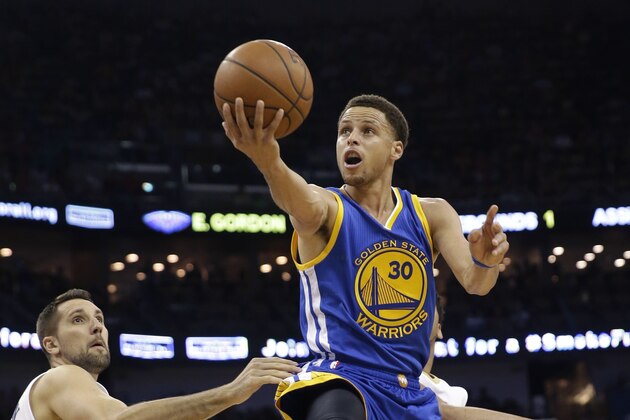 Golden State Warriors guard Stephen Curry (30) drives to the basket in front of New Orleans Pelicans forward Ryan Anderson in the first half of an NBA basketball game in New Orleans, Tuesday, April 7, 2015. (AP Photo/Gerald Herbert)
