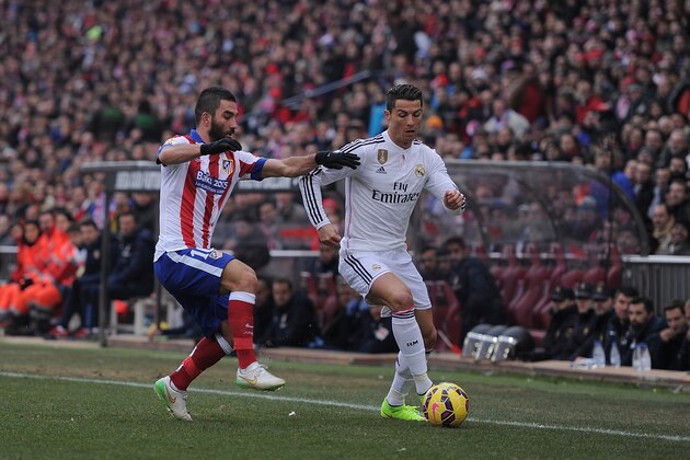 MADRID, SPAIN - FEBRUARY 07:  Cristiano Ronaldo of Real Madrid
is tackled by Arda Turan of Club Atletico de Madrid during the La Liga match between Club Atletico de Madrid and Real Madrid at Vicente Calderon Stadium on February 7, 2015 in Madrid, Spain.  (Photo by Denis Doyle/Getty Images)